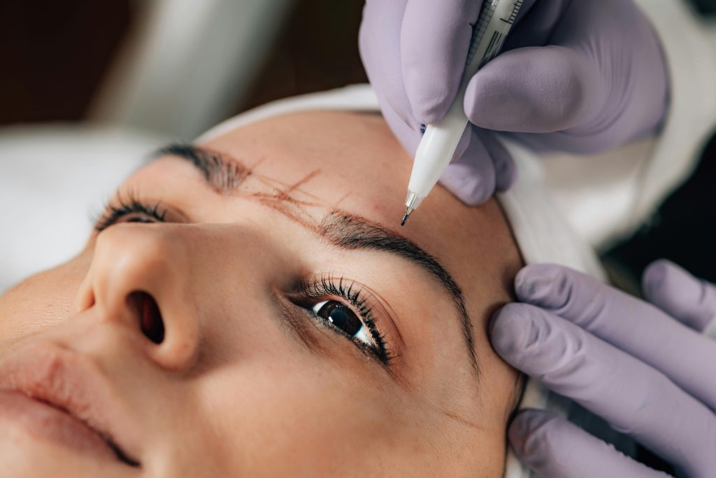 pexels-photo-8826403-8826403 A beautician performs precise microblading on a client's eyebrows in a salon.